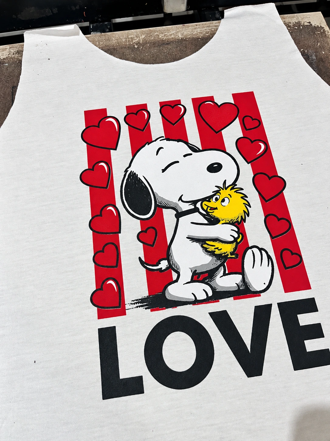 Estampa à base d’água com Snoopy, Woodstock, corações vermelhos e a palavra LOVE em tecido branco